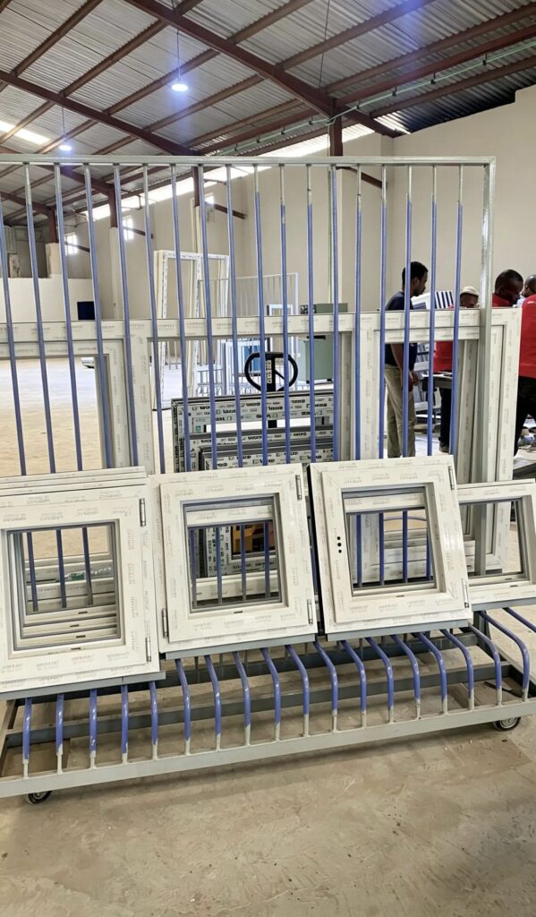 Finished white uPVC windows standing on a rack at the Rotex factory, ready for delivery