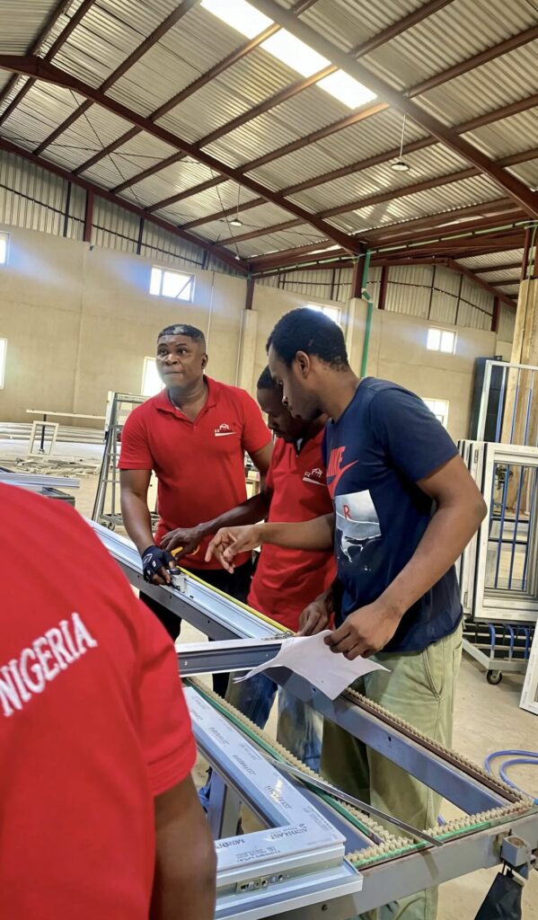 Rotex staff in branded shirts checking lengths of profile laid out along the factory workbench