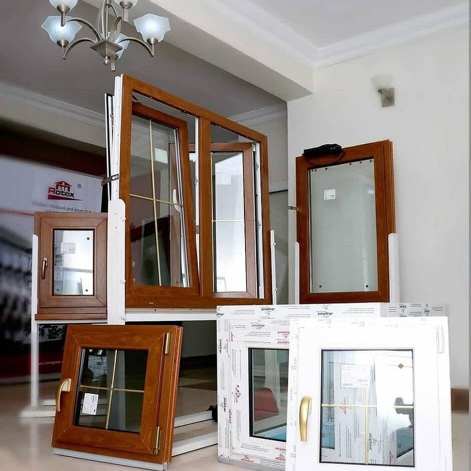 Woodgrain and white window samples on display in the Rotex showroom, one opened on its tilt and turn hinge